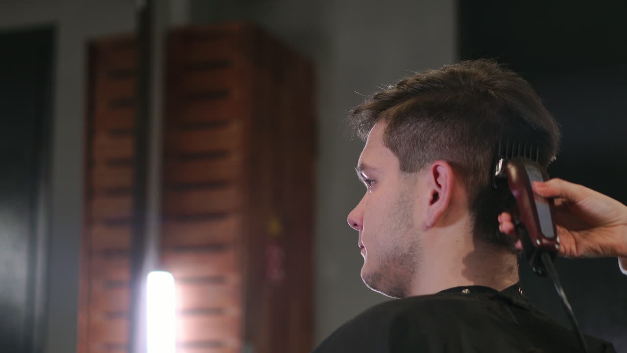 Men's hairstyling and haircutting in a barber shop or hair salon. Grooming the hair. Barbershop. Woman hairdresser doing haircut adult men in the men's hair salon. Haircutter in the workplace