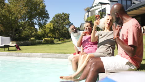 enjoying drinks by pool, senior friends relaxing and having fun together, copy space