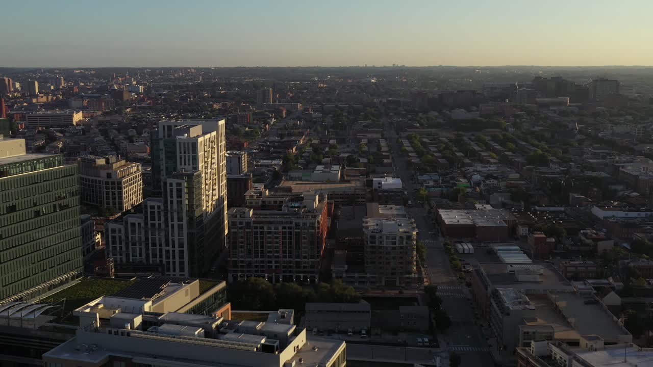 Panorâmica aérea em movimento revela grandes edifícios perto de Fells Point em Baltimore, Maryland, ao nascer do sol na hora dourada