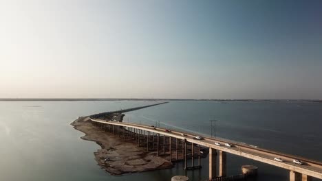 Vista-Aérea-De-Drones-Del-Puente-De-La-Calzada-Conmemorativa-Jfk-Y-Laguna-Madre-Entre-La-Isla-Del-Padre-Norte-Y-Corpus-Christi-Texas-En-Una-Tarde-Soleada