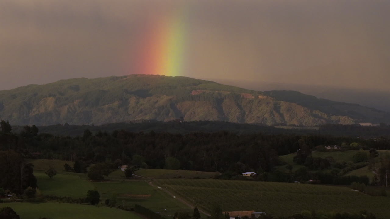 tomada de un avión no tripulado de las colinas, el arco iris y la cordillera cubierta de niebla, distrito de tasman, nueva zelanda