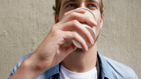 young man having coffee from disposable cup