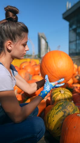 una mujer recogiendo una calabaza.