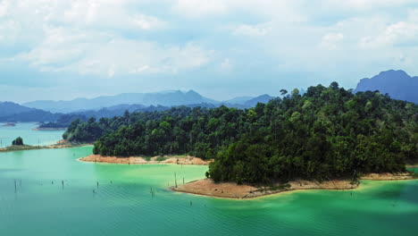 Sombras-De-Nubes-Moviéndose-En-Agua-Azul-En-La-Isla-Verde-Del-Bosque-Tropical,-Aérea