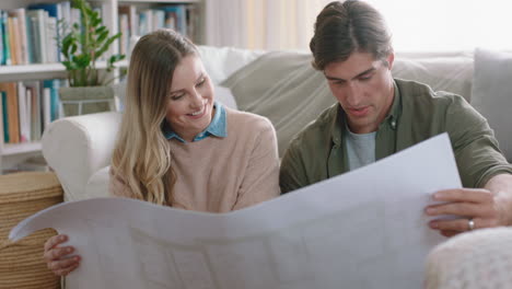 young couple looking at architectural plan of house planning home renovation project discussing interior design layout of floor plan sharing ideas 4k footage