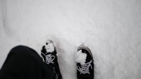 zapatos pov caminando a través de la tormenta de nieve fresca de invierno y dejando huellas