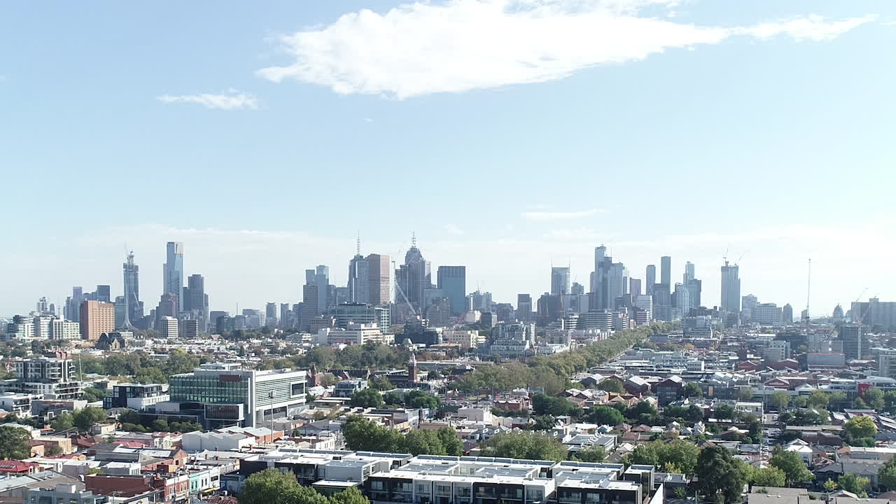 Aerial ascend and full focus to reveal Melbourne CBD skyline with busy traffic moving below