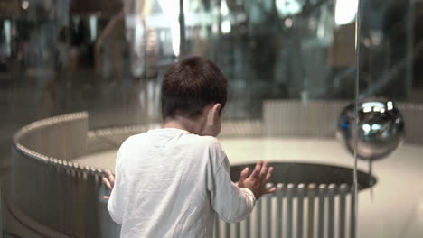 kid watching and loving the foucoult pendulum demonstrating the earth rotation