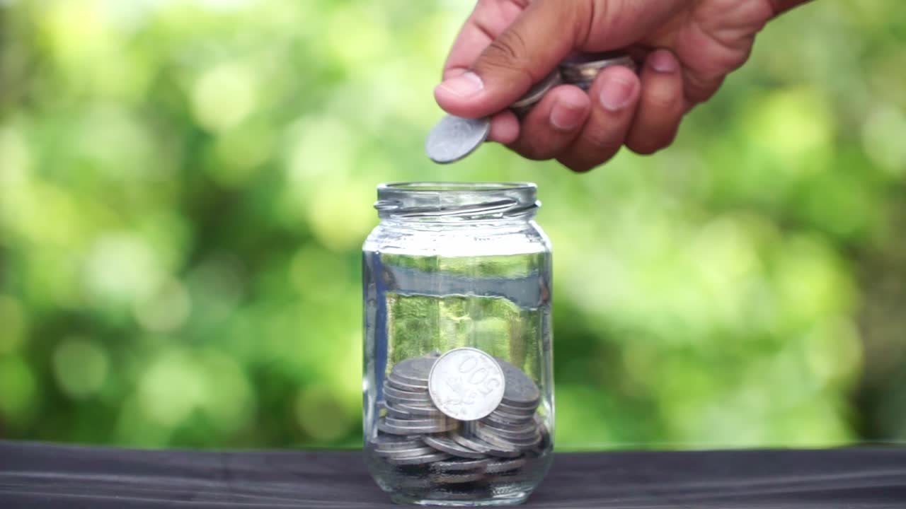 Person Saving Money in a Jar
