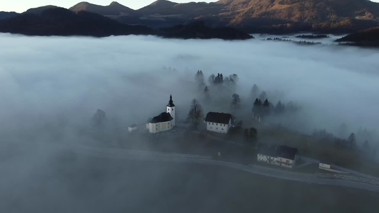 pueblo alpino en la niebla y el amanecer de la mañana