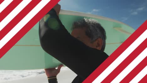 Animation-of-flag-of-united-states-of-america-over-senior-biracial-man-with-surfboard-on-beach