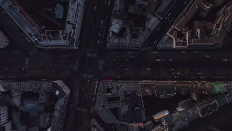 Top-down-footage-of-buildings-and-streets-in-city.-Poorly-illuminated-town-borough-at-dusk.-Paris,-France