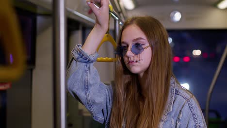 Tired,-bored-young-woman-standing-alone-in-bus-transport-after-hard-work-day-and-falling-asleep