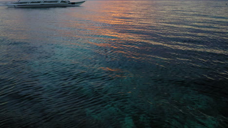 Aerial-view-of-a-Spider-boat-in-Moalboal-Beach-at-the-sunset,-Cebu,-Philippines