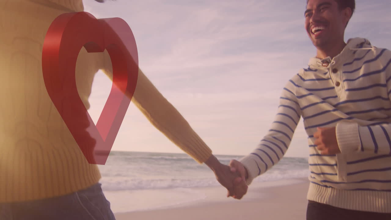 Holding hands on beach, couple enjoying sunset with heart animation overlay