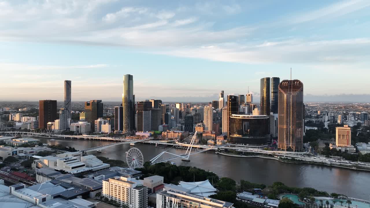 Langsom drone-orbit ved gylden time langs Brisbane River, med Queens Wharf og The Star Brisbane tårnene samt Neville Bonner Bridge og CBD-skyline, Brisbane, QLD, Australien