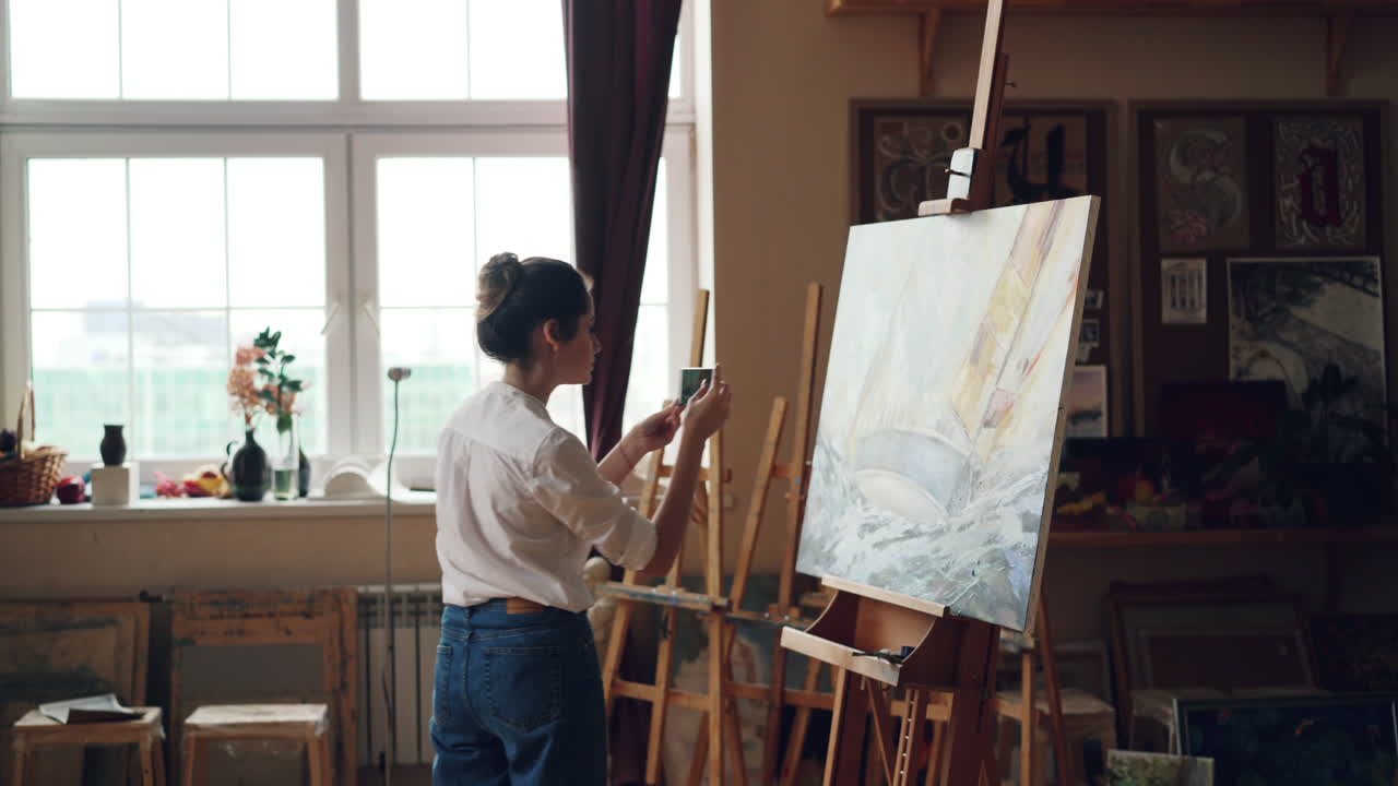 Woman Taking Photo of Painting in Art Studio