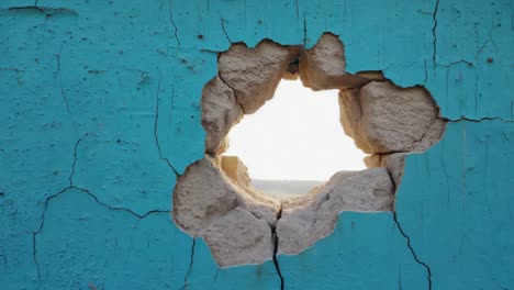 cracked blue wall with hole