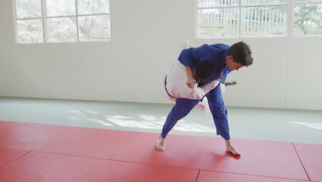 judokas training by doing a randori on the judo mat