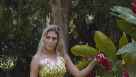 niña de cabello rubio jugando con una flor en el jardín