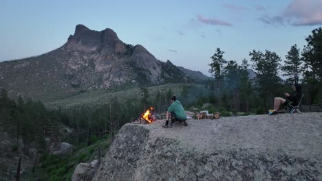 Freunde-Auf-Felsblock-Mit-Lagerfeuer,-Epischer-Blick-Auf-Sheeprock,-San-Isabel