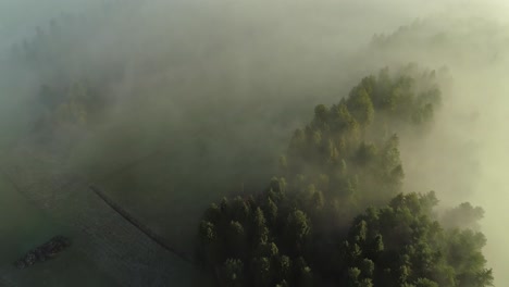 aerial backward over countryside covered of mist.