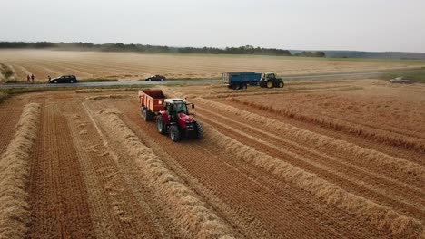 a cinematic 4k drone shot of two tractors working in a field in france, showcasing agriculture with an epic view of a corn field