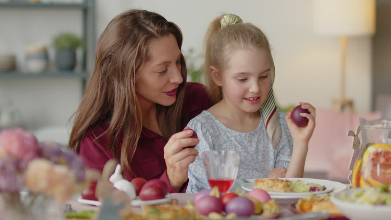 Mom and Daughter Playing Egg Tapping on Easter Dinner
