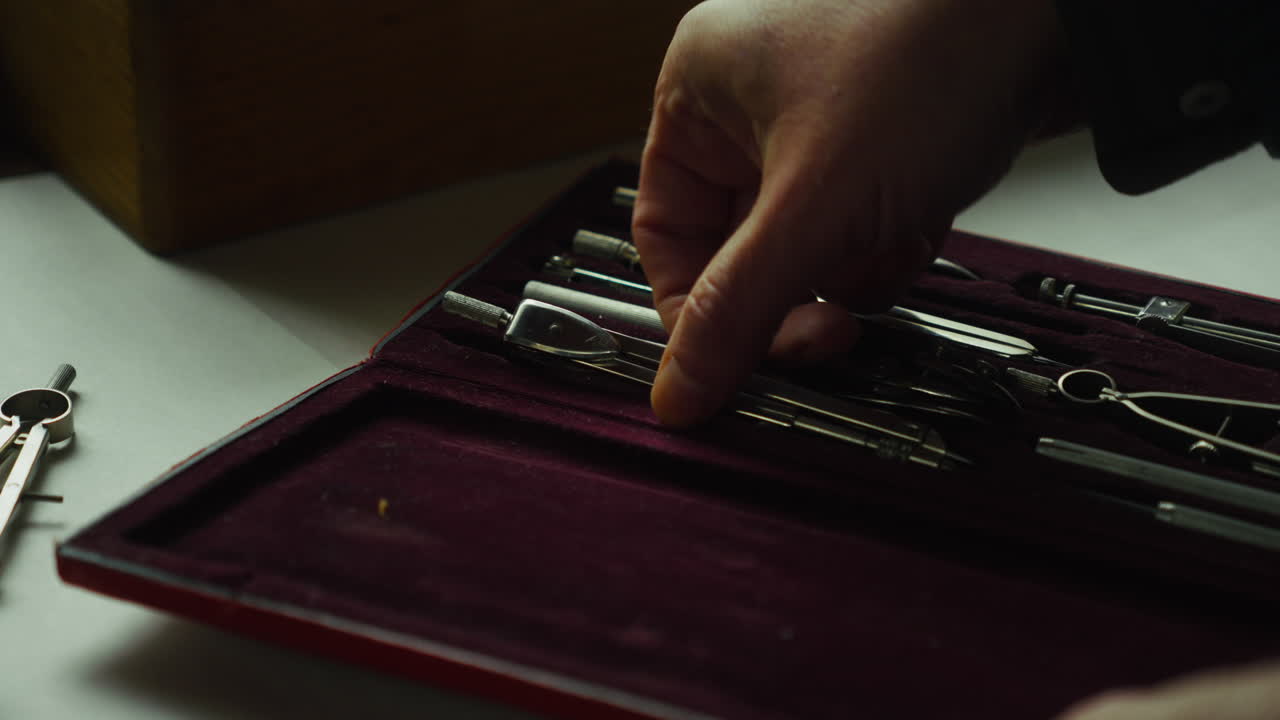 Close-up of a tool case opening to reveal drafting instruments, with compass set aside, suggesting readiness, planning, and the start of focused technical work