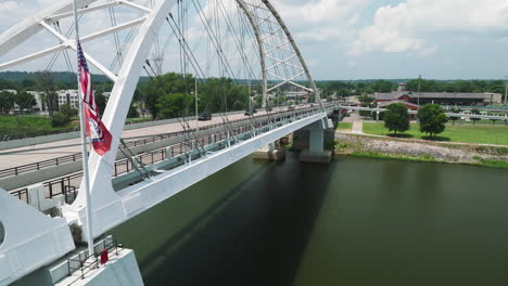 broadway bridge with flags of america and arkansas across the arkansas river in little rock, arkansas, usa