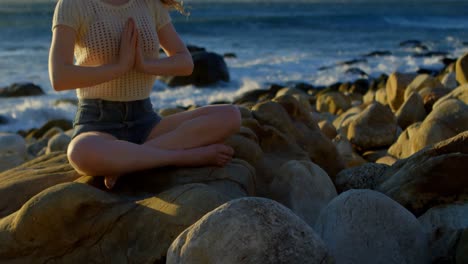 mujer realizando yoga en la playa 4k