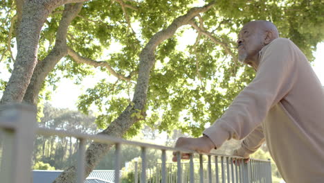 Thoughtful-senior-biracial-man-admiring-view-at-balcony-at-home,-slow-motion