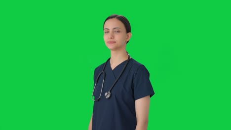 retrato de una feliz doctora india de pie con las manos cruzadas pantalla verde