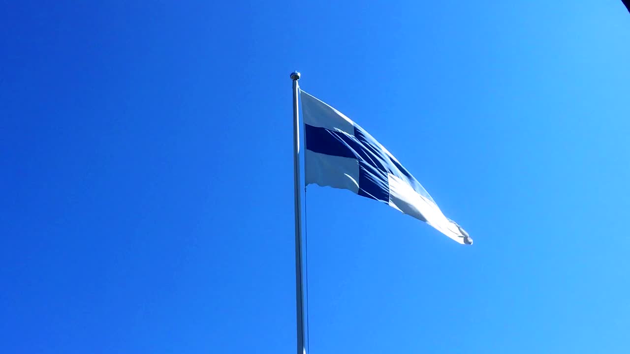 파란색 십자가가 있는 흰색 핀란드 깃발 흔들기