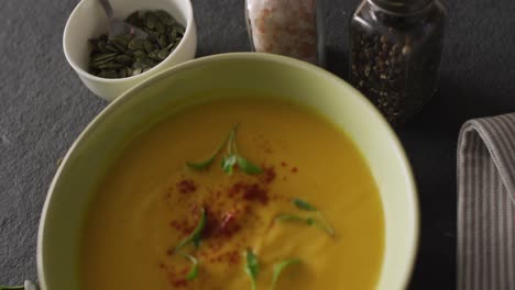 video of cream vegetable soup in bowl on grey table with spices