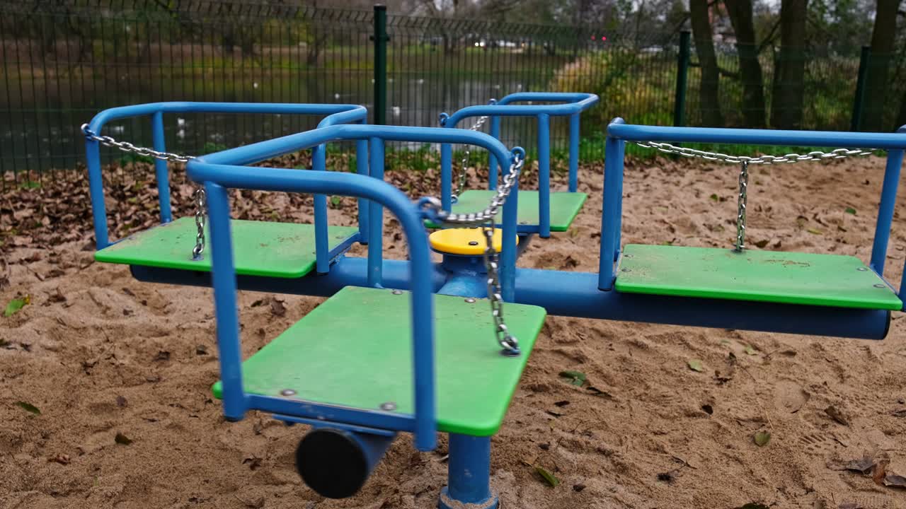 пустая карусель, вращающаяся на общественной игровой площадке