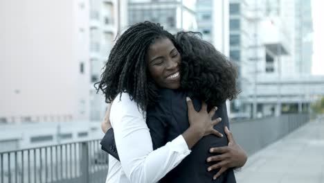 two happy women embracing on street