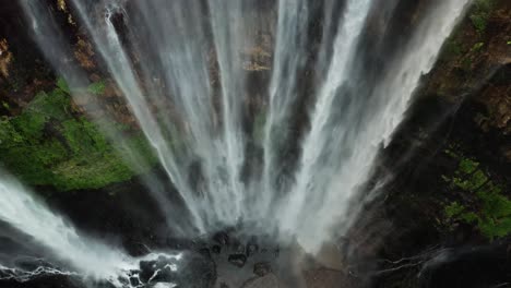 a stunning view of a waterfall cascading into a flowing river, surrounded by lush natural scenery. the rhythmic motion of water and ambient sounds evoke tranquility,