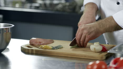 las manos del chef cortando la vegetación en la cocina. un primer plano de las manos del chef cortando verduras