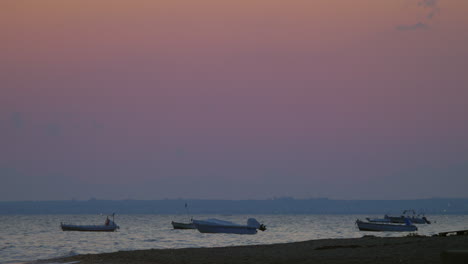 Barcos-A-Motor-Amarrados-Balanceándose-Sobre-Las-Olas-Del-Mar-Al-Atardecer