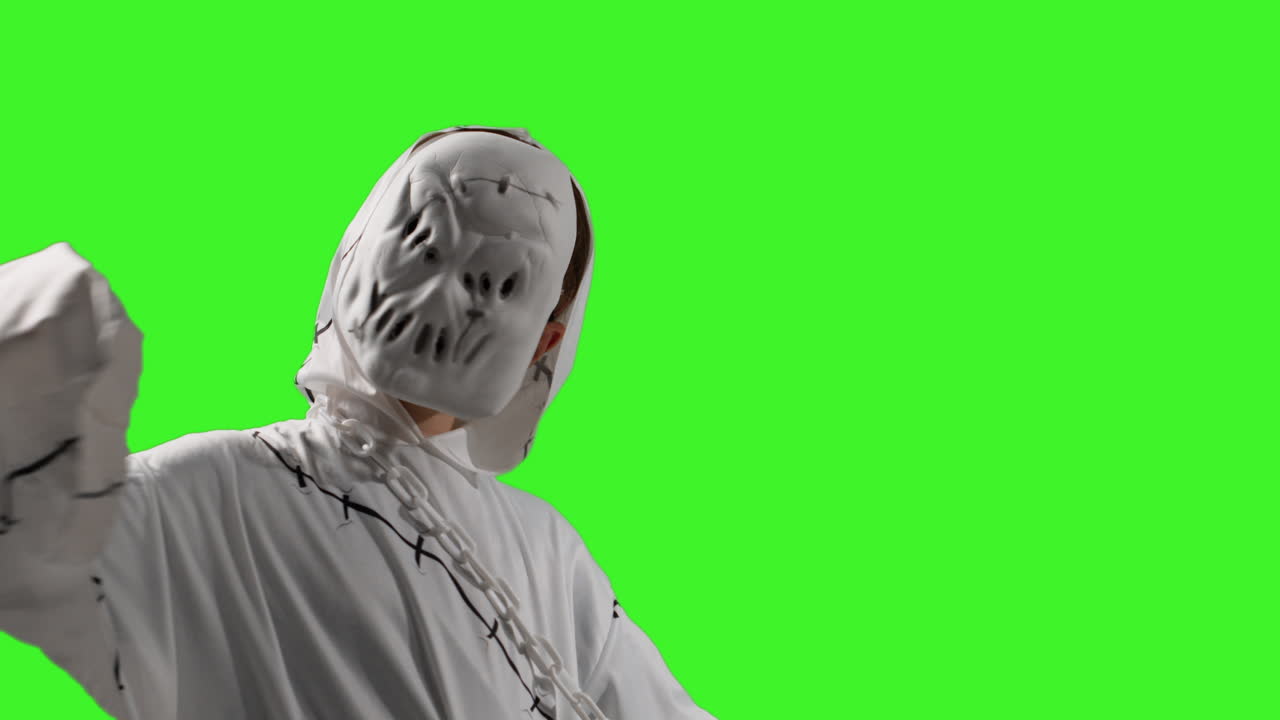 유령, 좀비, 괴물 의상을 입은 아이가 할로윈에 장난을 치고 스튜디오 녹색 화면 배경에 프레임을 가로질러 고 있습니다.