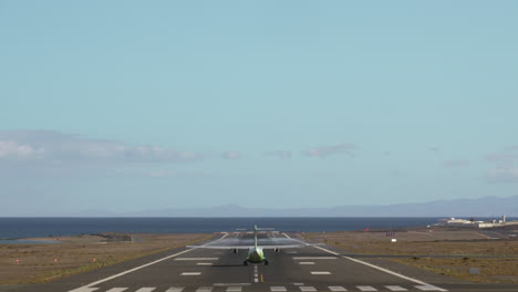 airliner leaving airport in coastal city back view