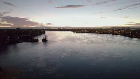 Flying-near-power-lines-over-a-beautiful-river-at-sunrise