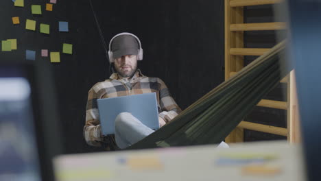 comfortable man works on laptop in modern office workplace