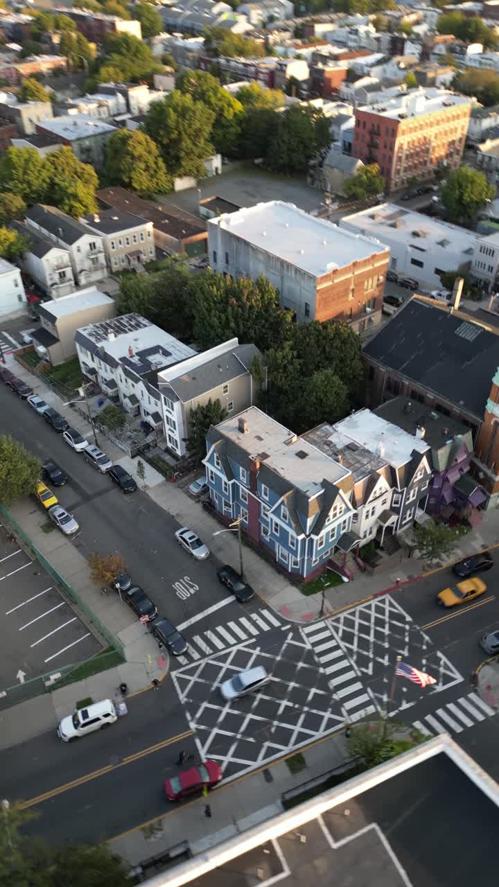 Droneoptagelser stiger op fra en beboelsesgade i Jersey City og tipper langsomt op for at afsløre den fantastiske skyline af downtown Manhattan på tværs af Hudson River under en smuk gylden time.