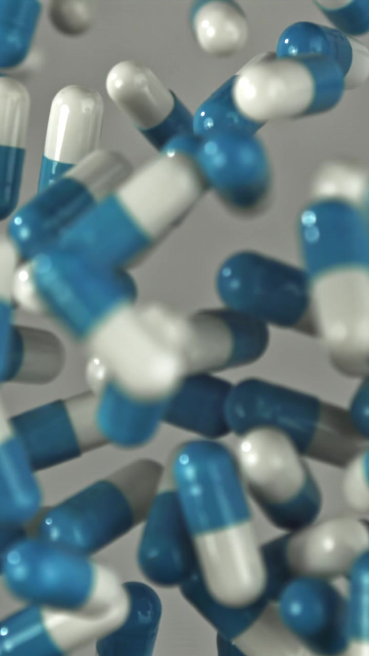 Capsule mediche blu e bianche che cadono al rallentatore