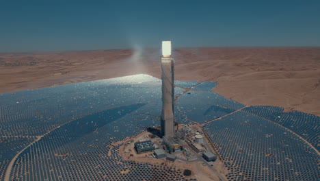 La-Torre-De-Energía-Solar-Enfocó-La-Luz-Del-Sol-Para-Los-Espejos-Móviles-En-El-Sol-Del-Desierto-Sin-Tiempo-En-Un-Día-Sin-Nubes2:-Disparo-De-Un-Dron-De-Paralax-De-Seguimiento-Lento-Desde