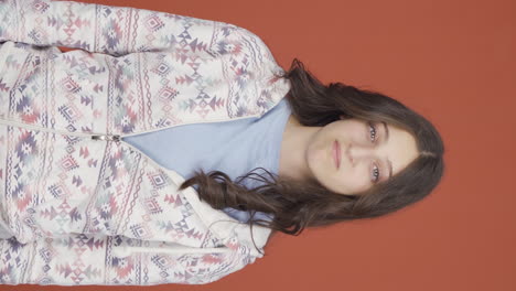 Vertical-video-of-Young-woman-looking-at-camera-with-a-negative-expression.