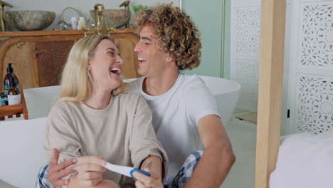 la pareja reacciona a una prueba de embarazo positiva