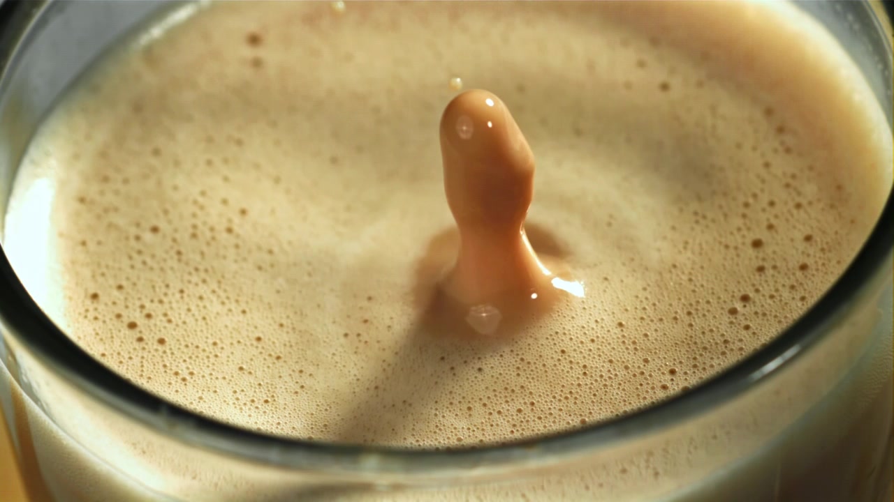 Goccia al rallentatore che schizza nel caffè latte cremoso
